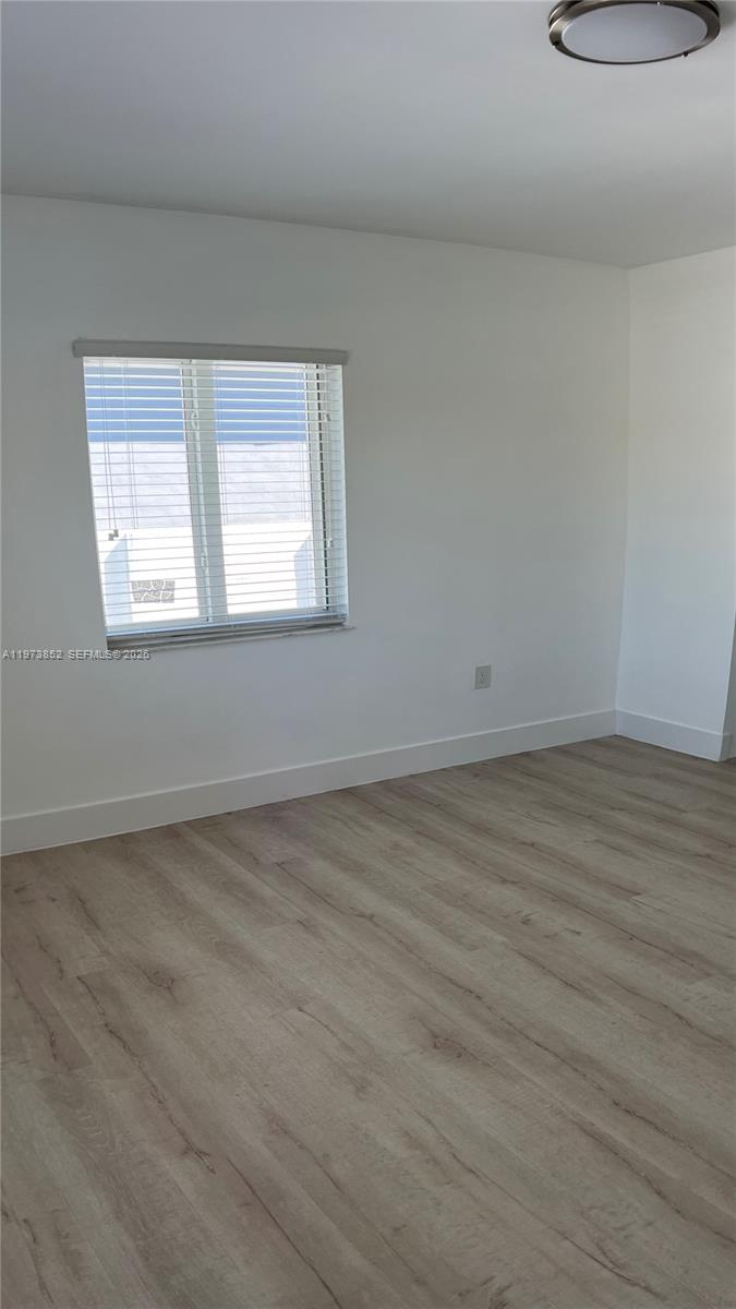 2800 Southwest 25th Street, Unit 1 Miami, FL 33133 - Photo 23 of 48 an empty room with wooden floor and windows