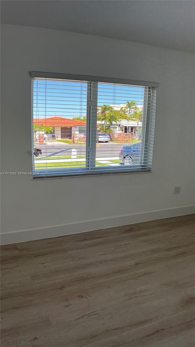 2800 Southwest 25th Street, Unit 1 Miami, FL 33133 - Photo 24 of 48 a view of an empty room with wooden floor and a window