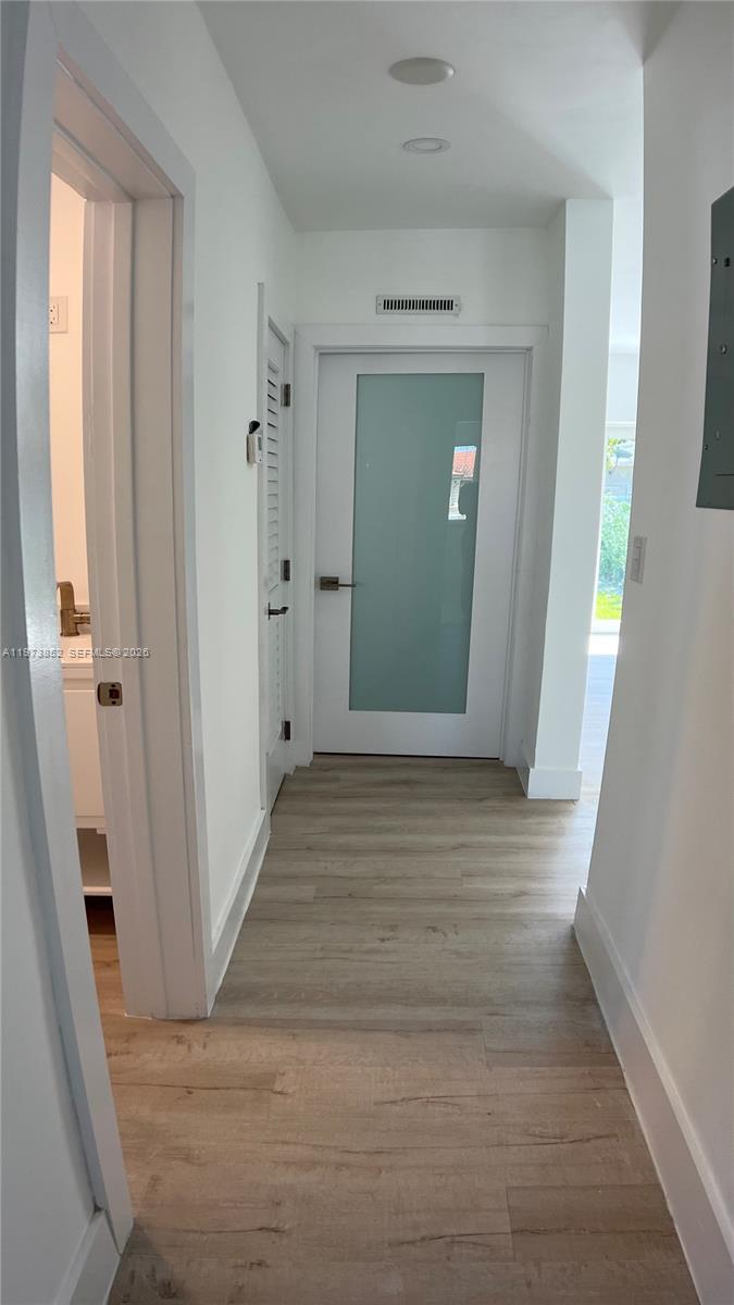2800 Southwest 25th Street, Unit 1 Miami, FL 33133 - Photo 31 of 48 a view of a hallway with wooden floor and closet area