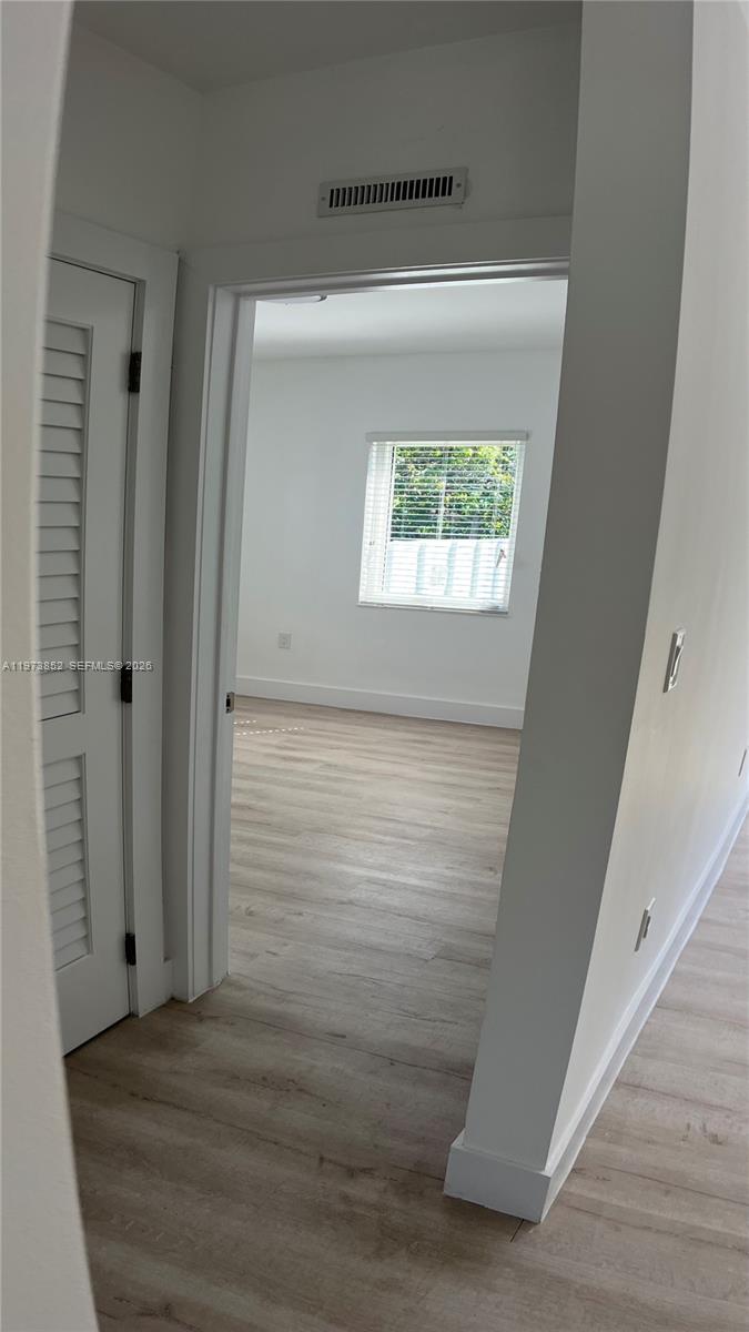 2800 Southwest 25th Street, Unit 1 Miami, FL 33133 - Photo 32 of 48 a view of a small space with wooden floor and a window