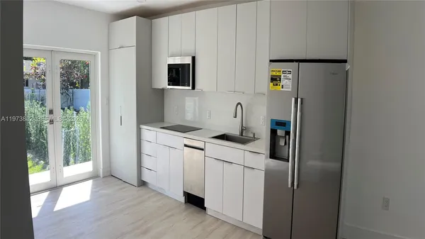 a kitchen with stainless steel appliances a refrigerator sink and microwave