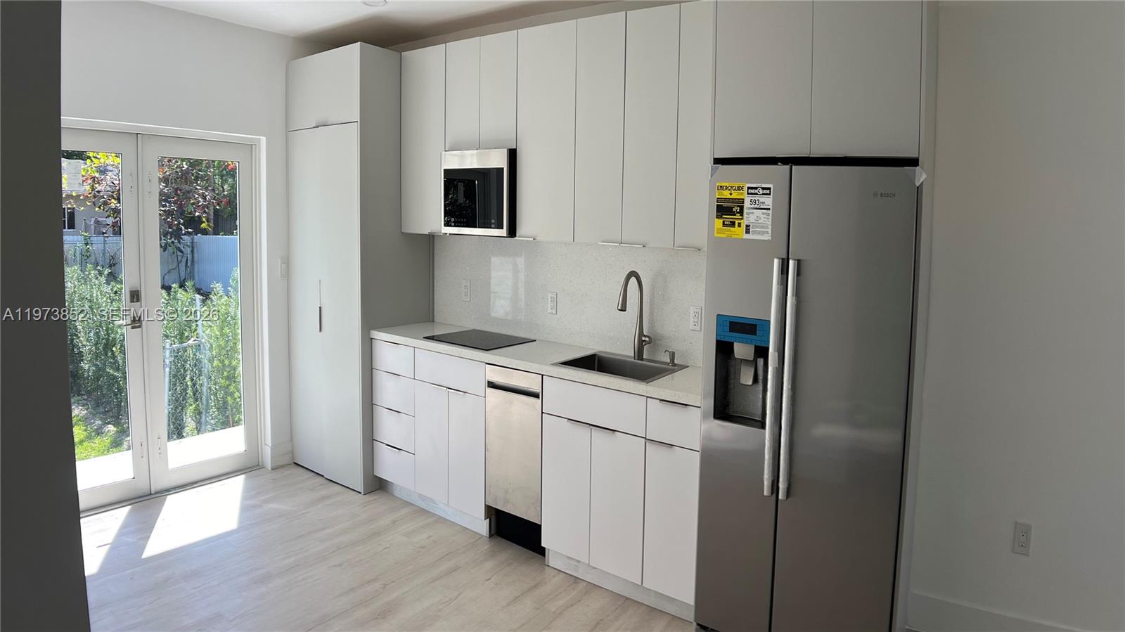2800 Southwest 25th Street, Unit 1 Miami, FL 33133 - Photo 10 of 48 a kitchen with stainless steel appliances a refrigerator sink and microwave