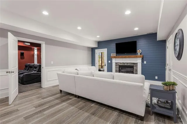 a living room with furniture a flat screen tv and a fireplace