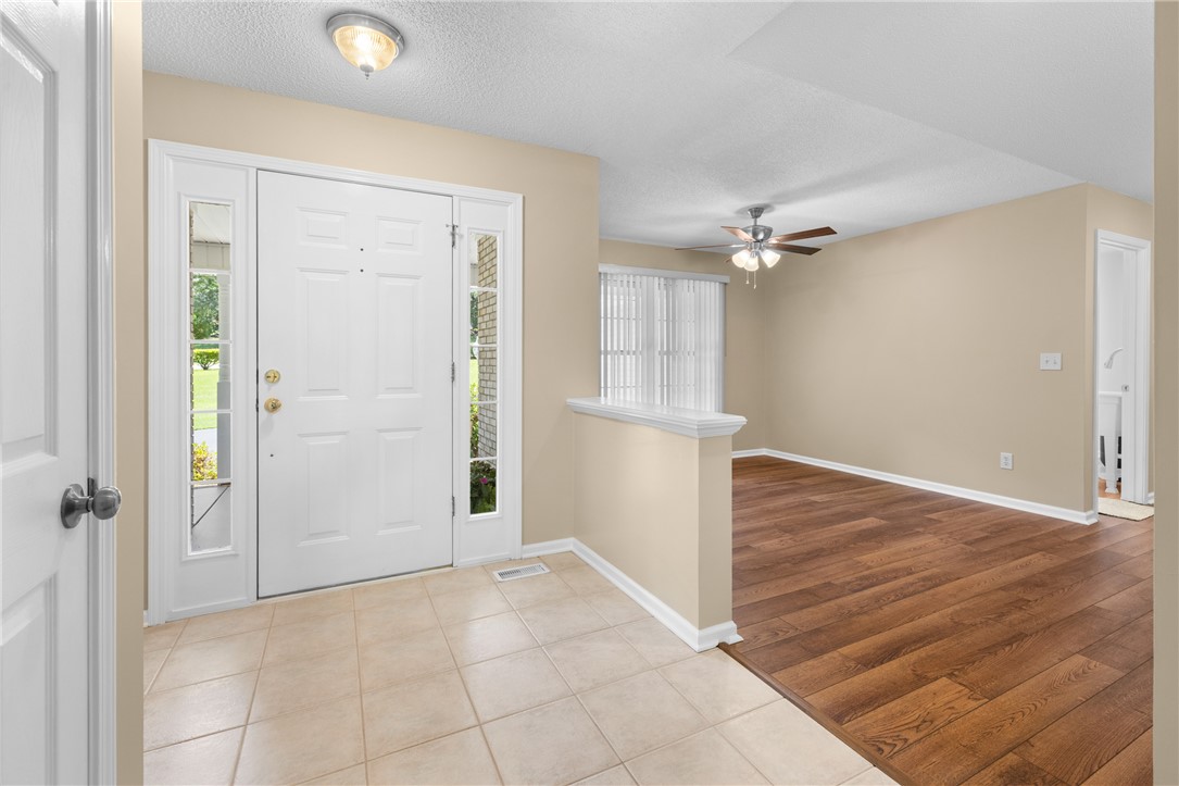 429 Burns Mill Road West Union, SC 29696 - Photo 5 of 49 A welcoming entry features practical tile flooring transitioning to rich hardwood, illuminated by a ceiling light fixture.