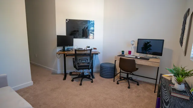 a view of a workspace with furniture and a window