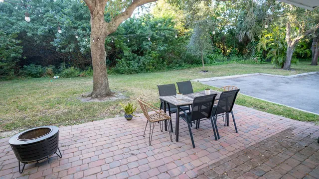 a view of a backyard with table and chairs in a patio