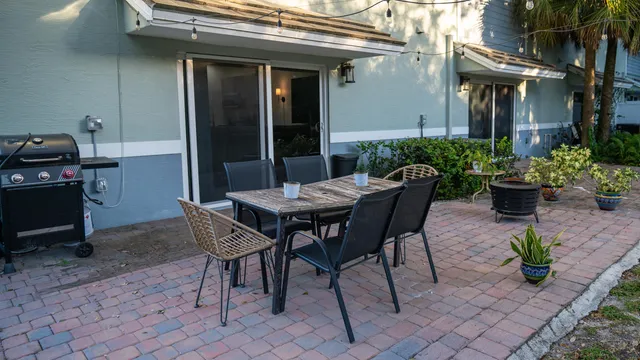 a view of a patio with table and chairs potted plants
