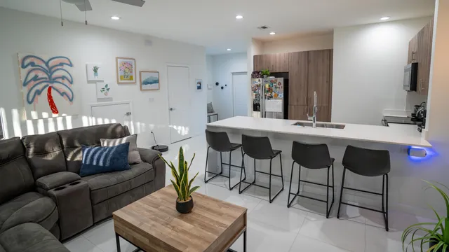 a living room with furniture and a refrigerator