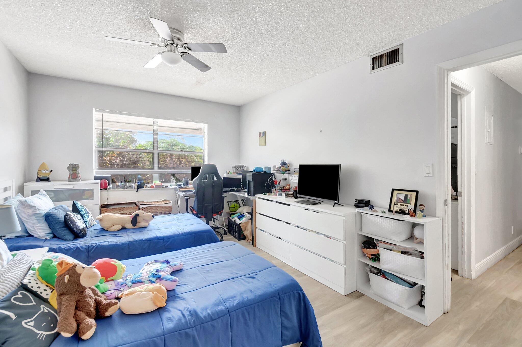 1124 Northwest 13th Street, Unit 208 Boca Raton, FL 33486 - Photo 12 of 23 a room with furniture and a flat screen tv