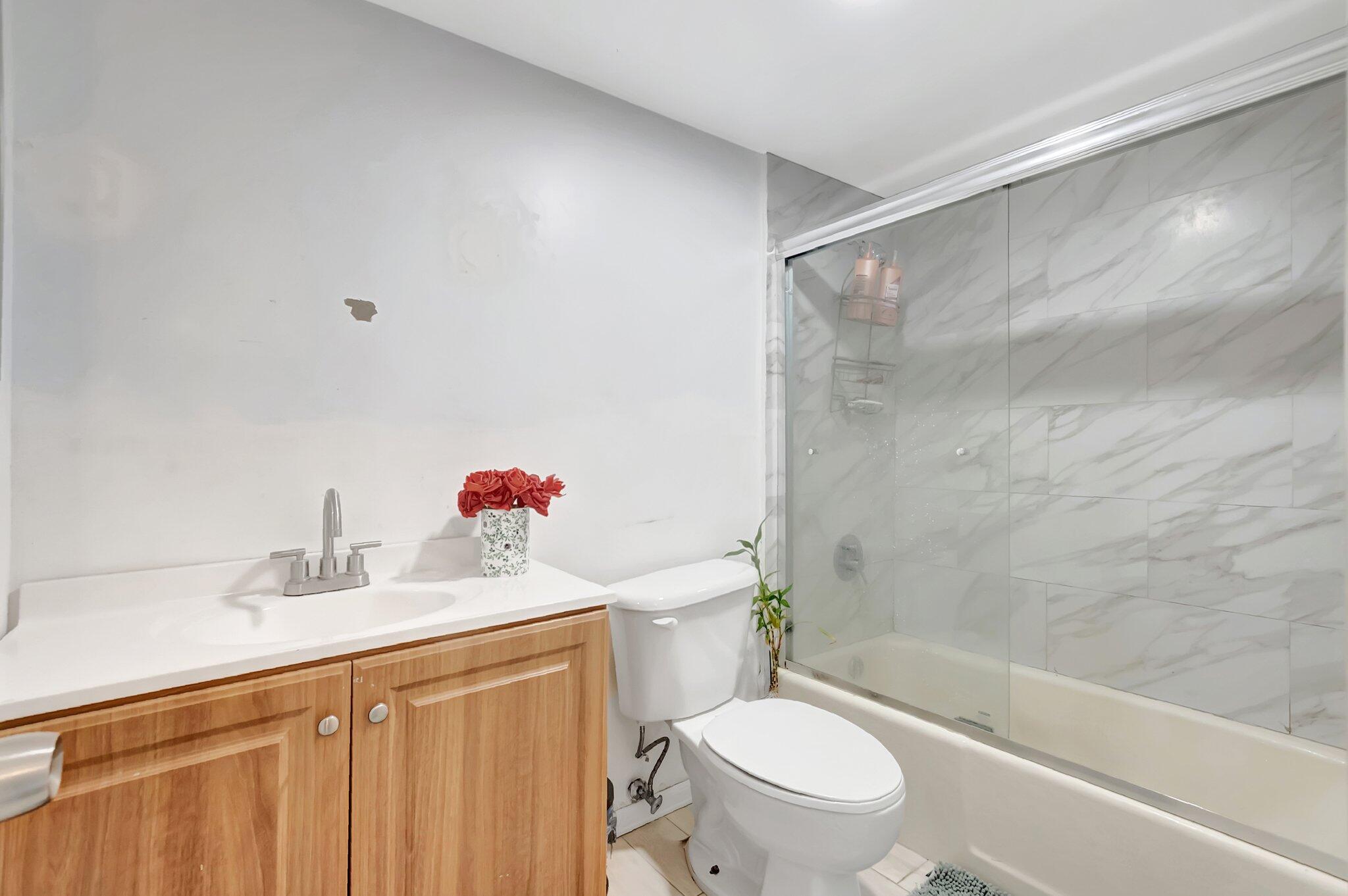 1124 Northwest 13th Street, Unit 208 Boca Raton, FL 33486 - Photo 13 of 23 a bathroom with a sink a toilet and a bathtub