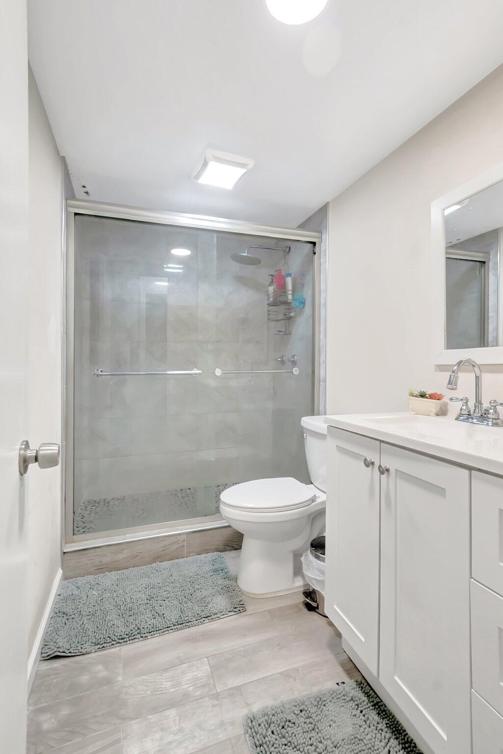 1124 Northwest 13th Street, Unit 208 Boca Raton, FL 33486 - Photo 18 of 23 a bathroom with a sink toilet and shower