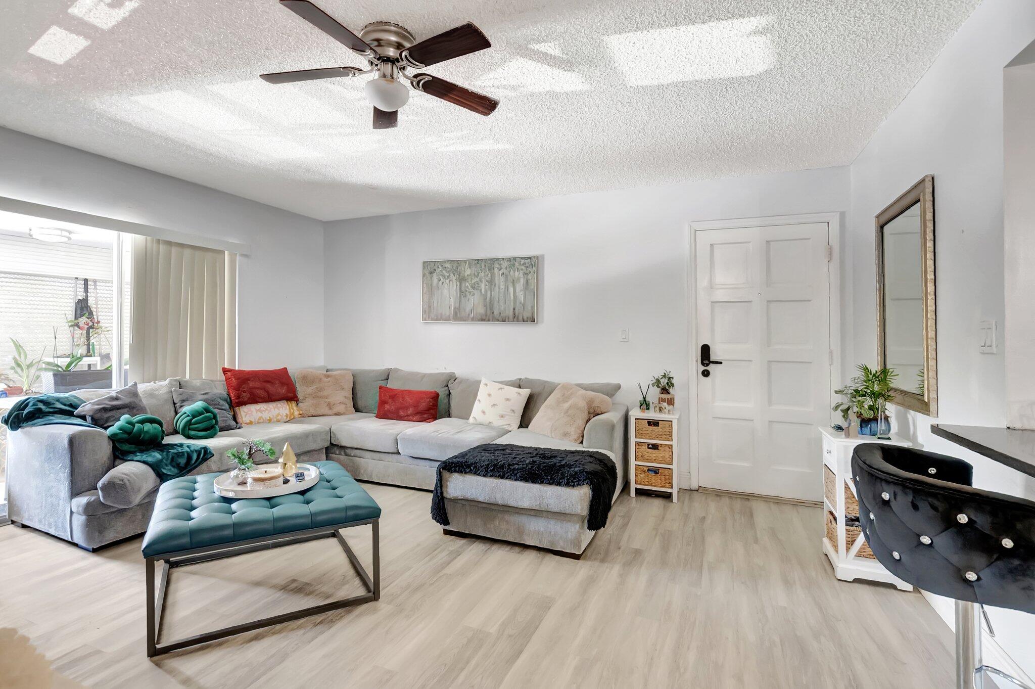 1124 Northwest 13th Street, Unit 208 Boca Raton, FL 33486 - Photo 5 of 23 a living room with furniture and a wooden floor