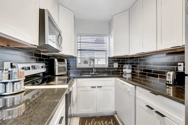 a kitchen with stainless steel appliances granite countertop a stove and a sink