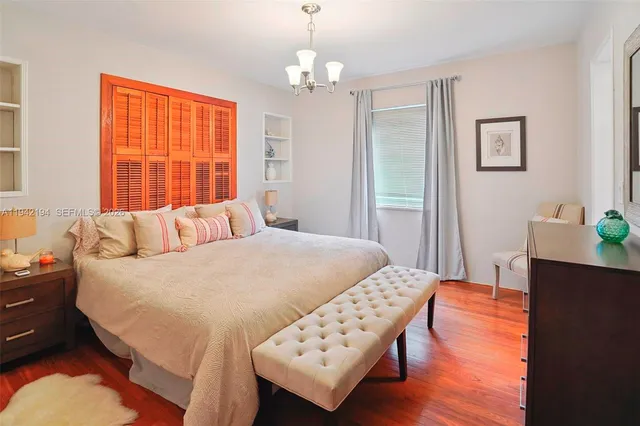 a bedroom with a bed and a wooden floor