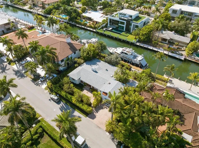 an aerial view of a house with a garden and lake view