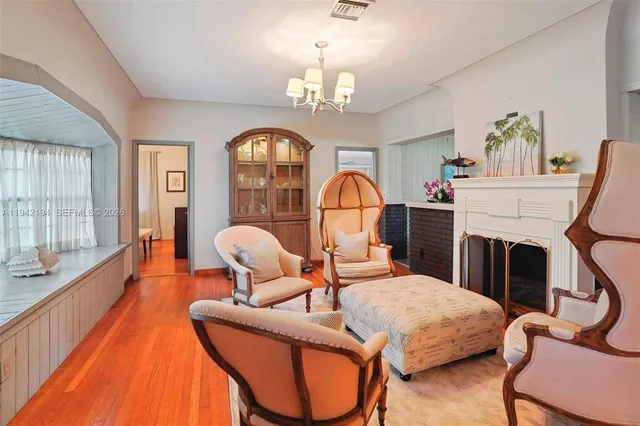 a living room with furniture a fireplace and a chandelier