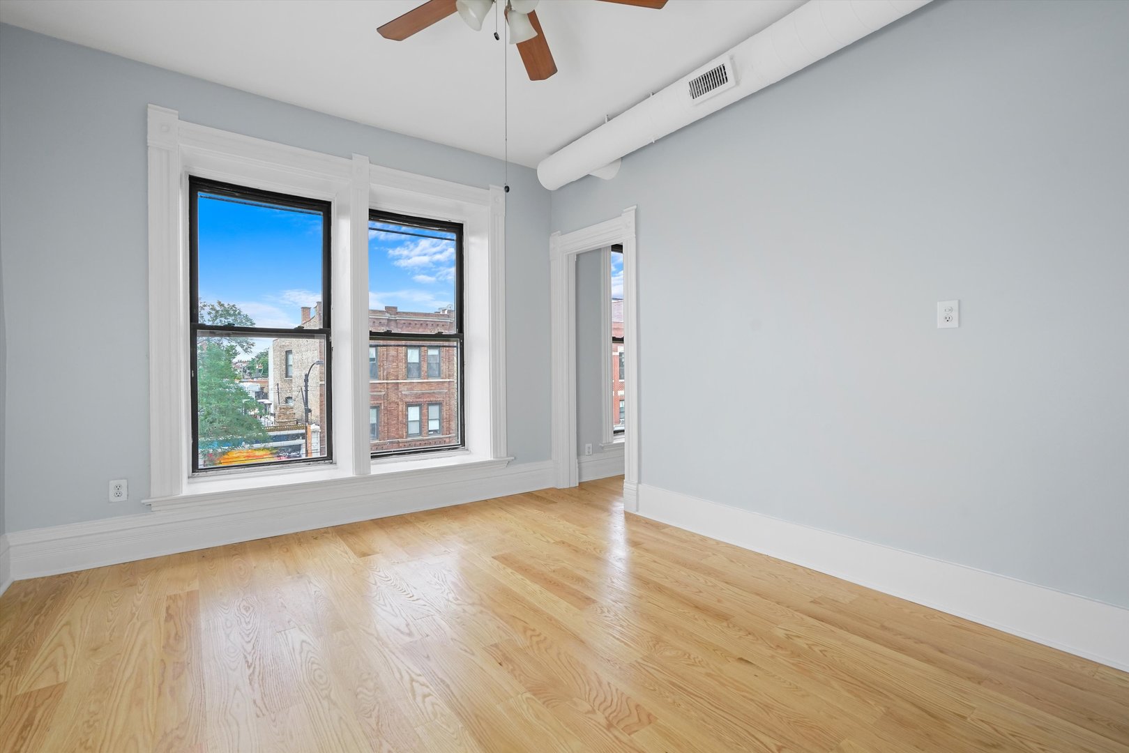 Undisclosed Address Chicago, IL 60622 - Photo 3 of 17 a view of an empty room with a window and wooden floor