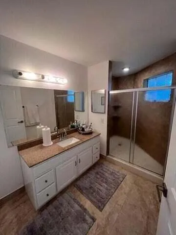a spacious bathroom with a granite countertop sink a mirror and a bathtub