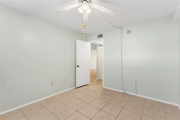 an empty room with chandelier fan