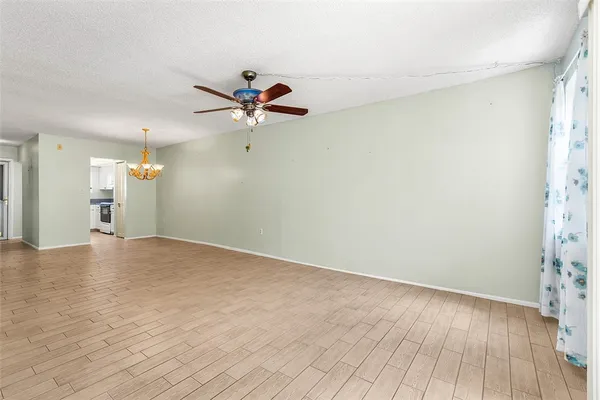 a view of a room with a wooden floor and a ceiling fan