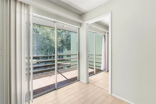 a view of empty room with wooden floor and windows