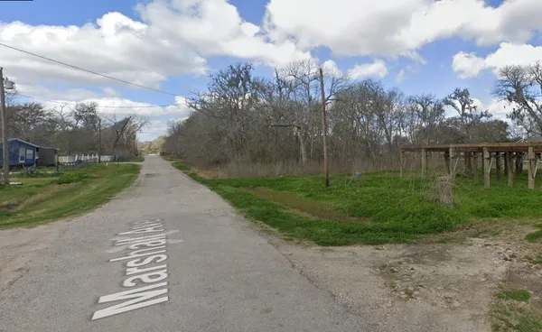 a view of a street with a yard in the back