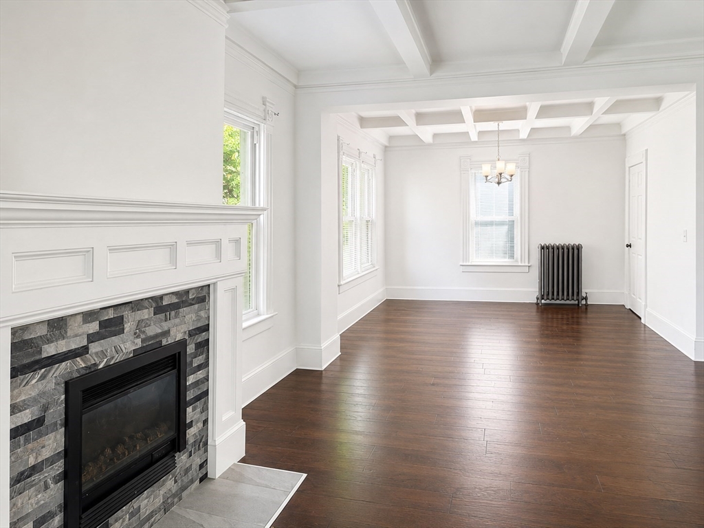 46 Mapledell Street Springfield, MA 01109 - Photo 2 of 8 a view of an empty room with wooden floor and fireplace