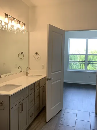 a spacious bathroom with a double vanity sink a mirror and a shower