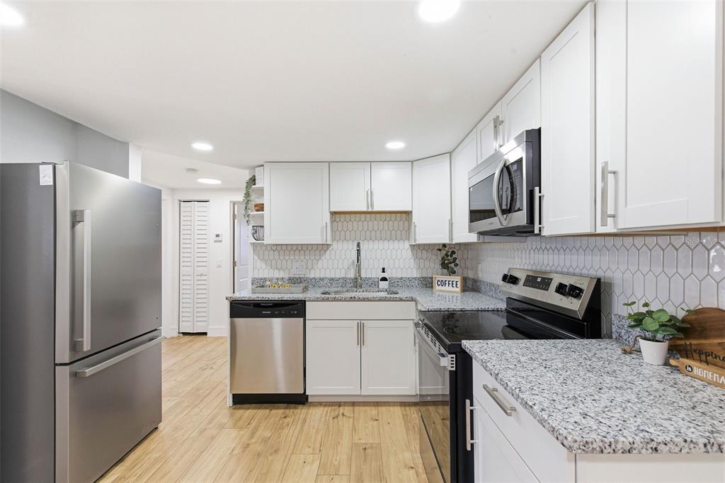 6338 Nashua Drive Port Richey, FL 34668 - Photo 12 of 49 a kitchen with a sink a refrigerator a microwave and cabinets