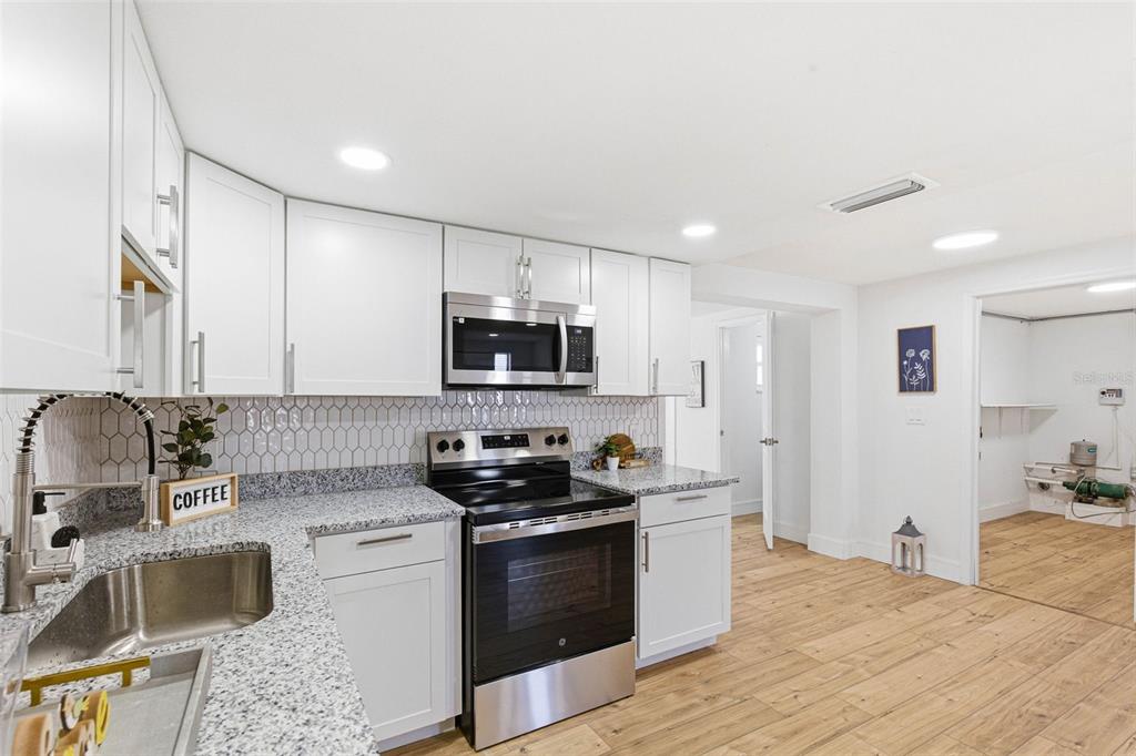 6338 Nashua Drive Port Richey, FL 34668 - Photo 13 of 49 a kitchen with stainless steel appliances granite countertop a sink stove and refrigerator