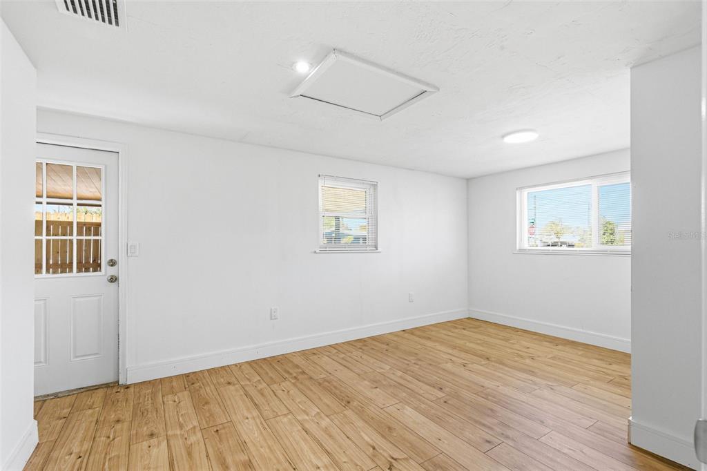 6338 Nashua Drive Port Richey, FL 34668 - Photo 24 of 49 an empty room with wooden floor and windows