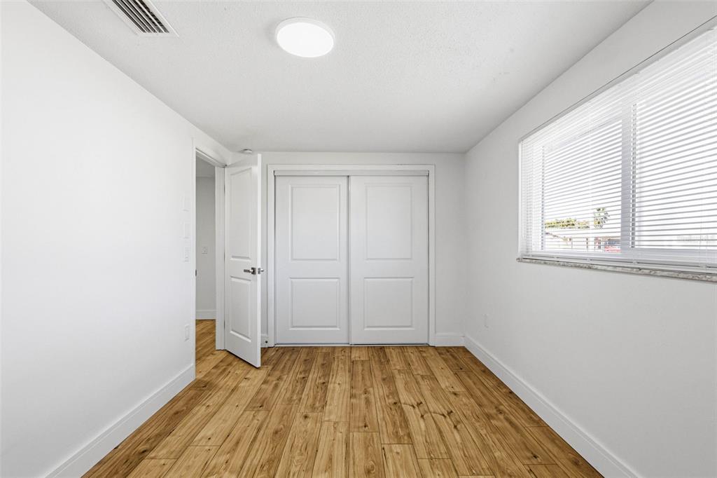 6338 Nashua Drive Port Richey, FL 34668 - Photo 32 of 49 an empty room with wooden floor and windows