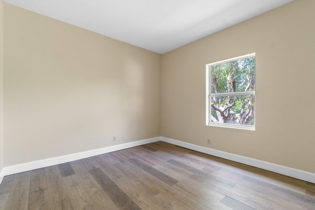 809 Talia Circle, Unit 809 TALIA CIRCLE Palm Springs, FL 33461 - Photo 16 of 23 an empty room with wooden floor and window