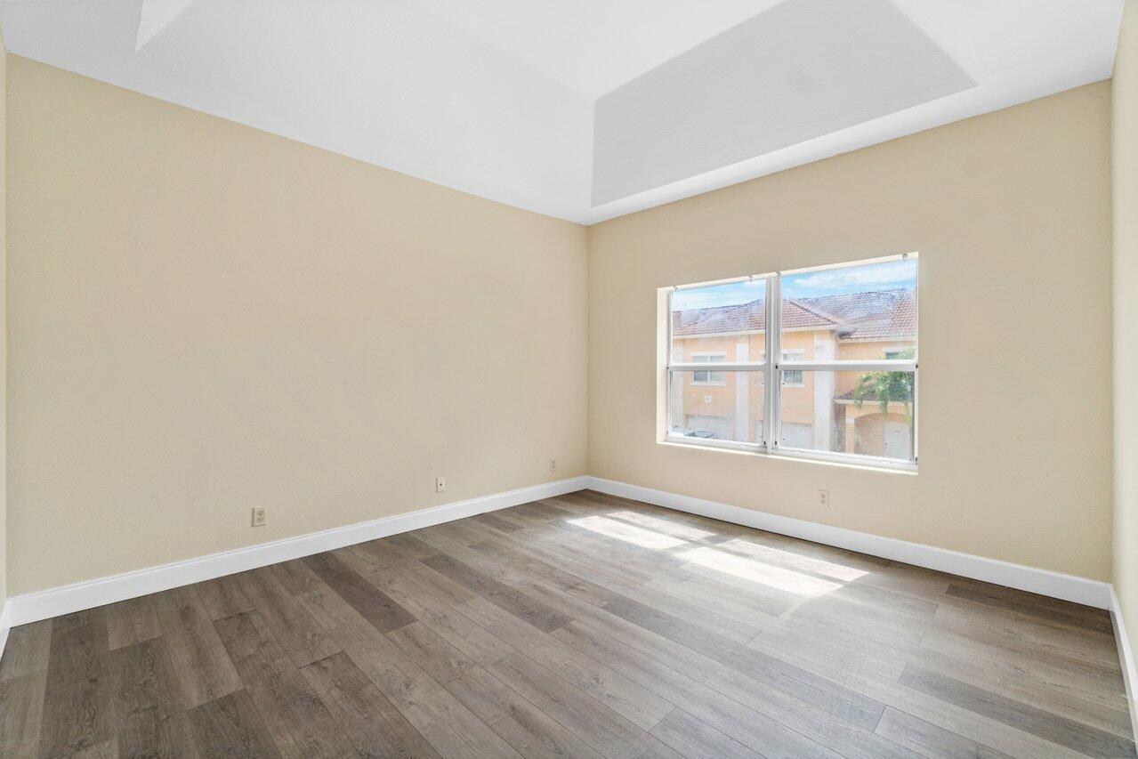 809 Talia Circle, Unit 809 TALIA CIRCLE Palm Springs, FL 33461 - Photo 19 of 23 an empty room with wooden floor and windows