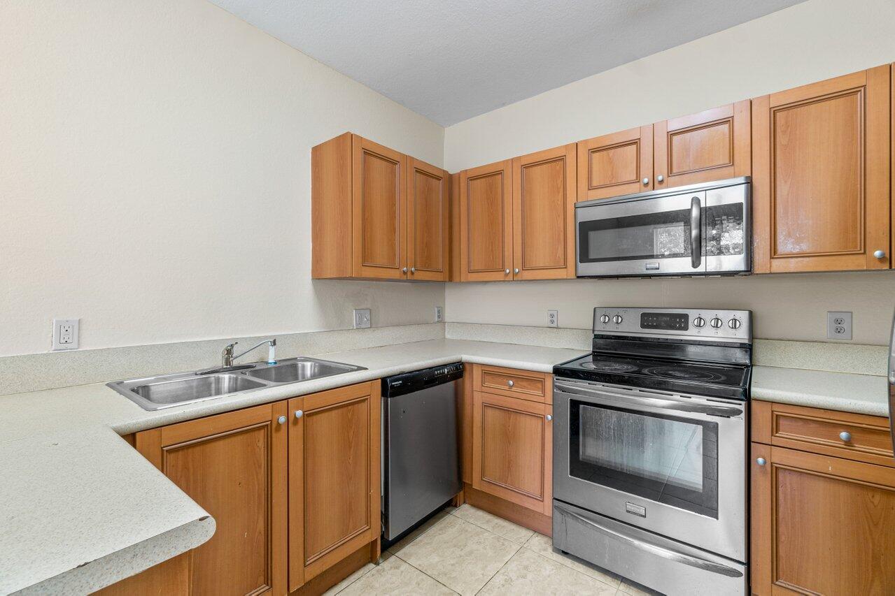 809 Talia Circle, Unit 809 TALIA CIRCLE Palm Springs, FL 33461 - Photo 10 of 23 a kitchen with stainless steel appliances granite countertop a sink stove and microwave