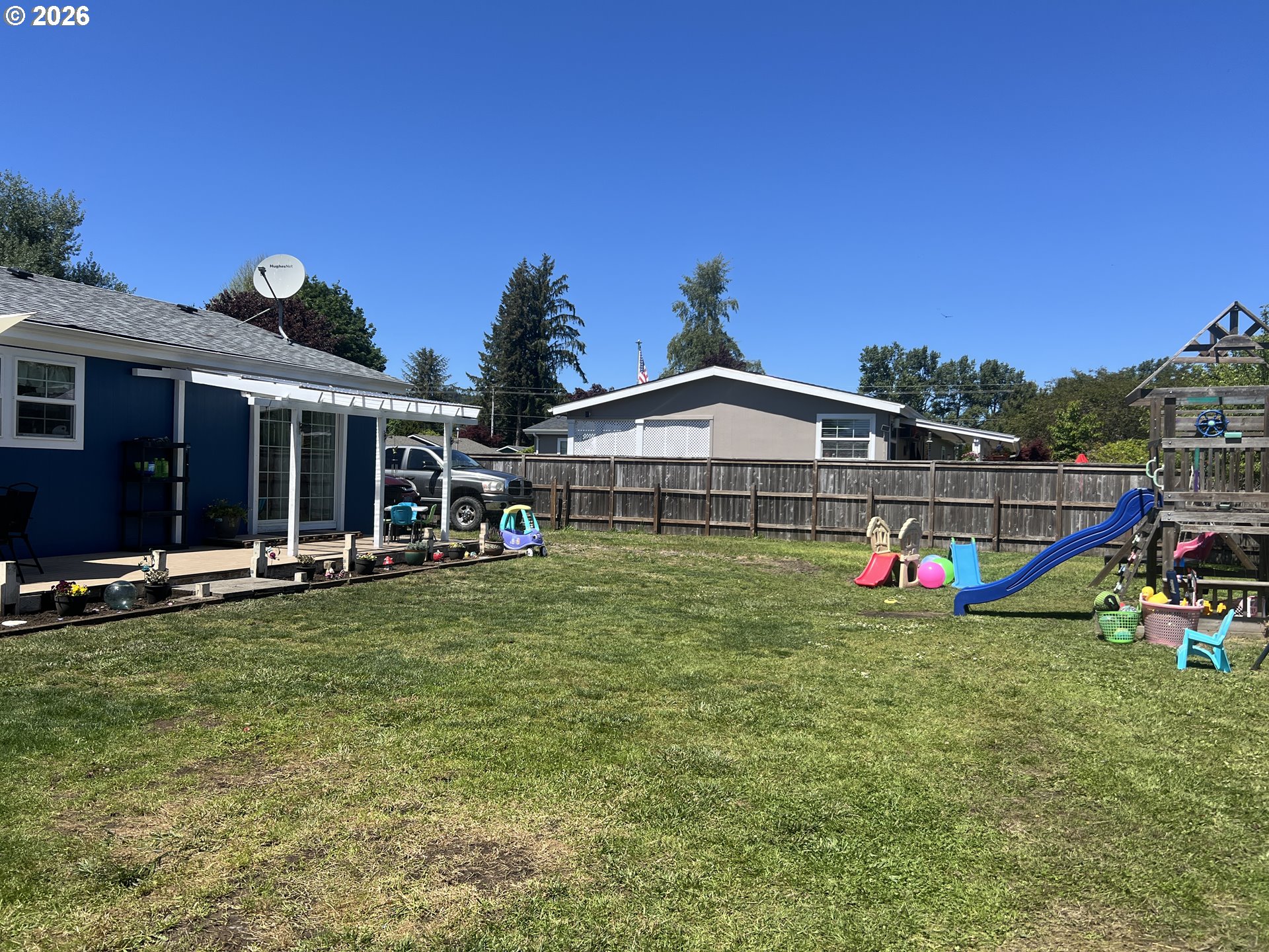 210 Northwest Grinstead Street Siletz, OR 97380 - Photo 28 of 29 a view of a house with table and chairs and wooden fence