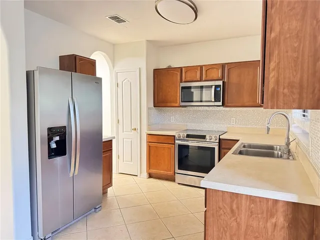 a kitchen with stainless steel appliances granite countertop a refrigerator and a stove top oven