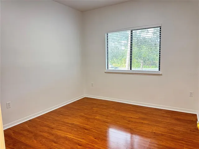 an empty room with wooden floor and a window