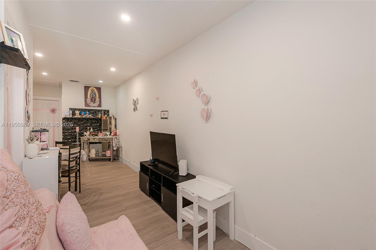 110 Northwest 58th Street Miami, FL 33127 - Photo 4 of 27 a living room with furniture a flat screen tv and kitchen view