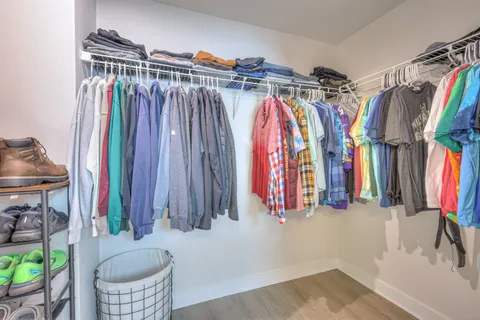 a view of walk in closet with clothes and shoes