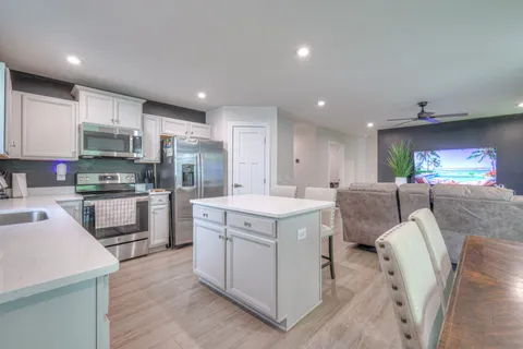 a kitchen with stainless steel appliances kitchen island granite countertop a sink and cabinets