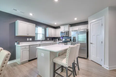 a kitchen with a sink a refrigerator a center island and cabinets