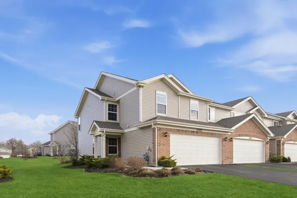 a front view of a house with a yard and garage