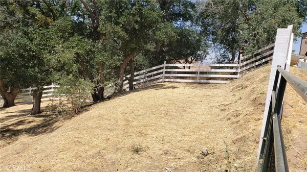 a view of a backyard with wooden fence and a bench