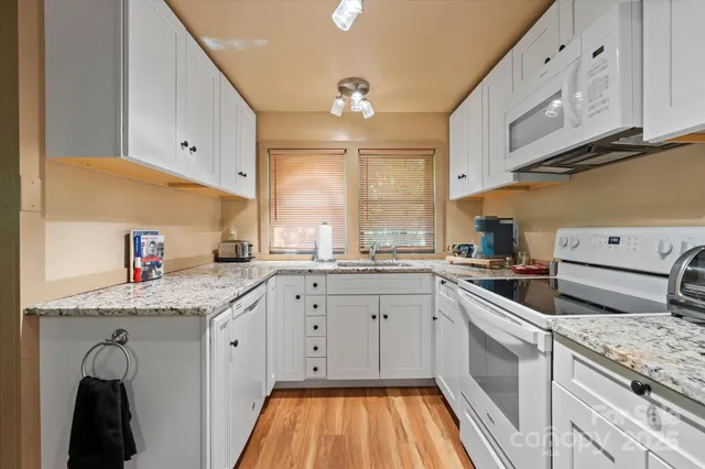 a kitchen with white cabinets and white appliances