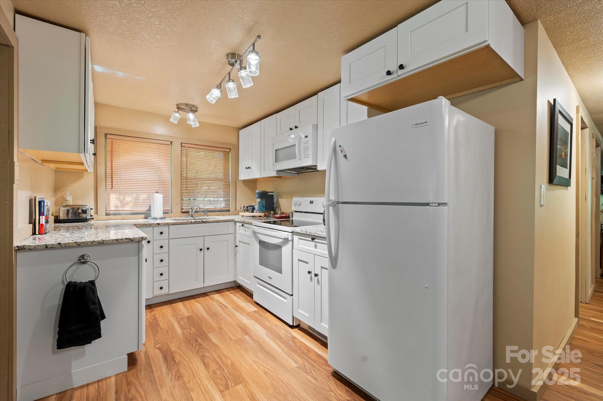 139 Ivy Ridge Church Road Mars Hill, NC 28754 - Photo 15 of 37 a kitchen with white cabinets and white appliances