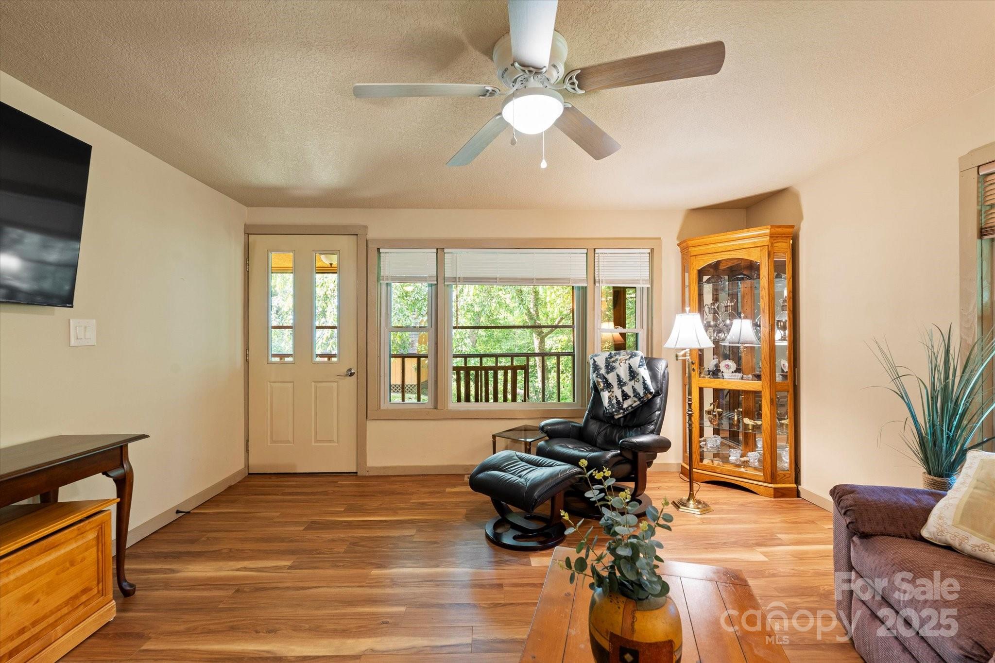 139 Ivy Ridge Church Road Mars Hill, NC 28754 - Photo 16 of 37 a living room with furniture floor to ceiling window and a flat screen tv