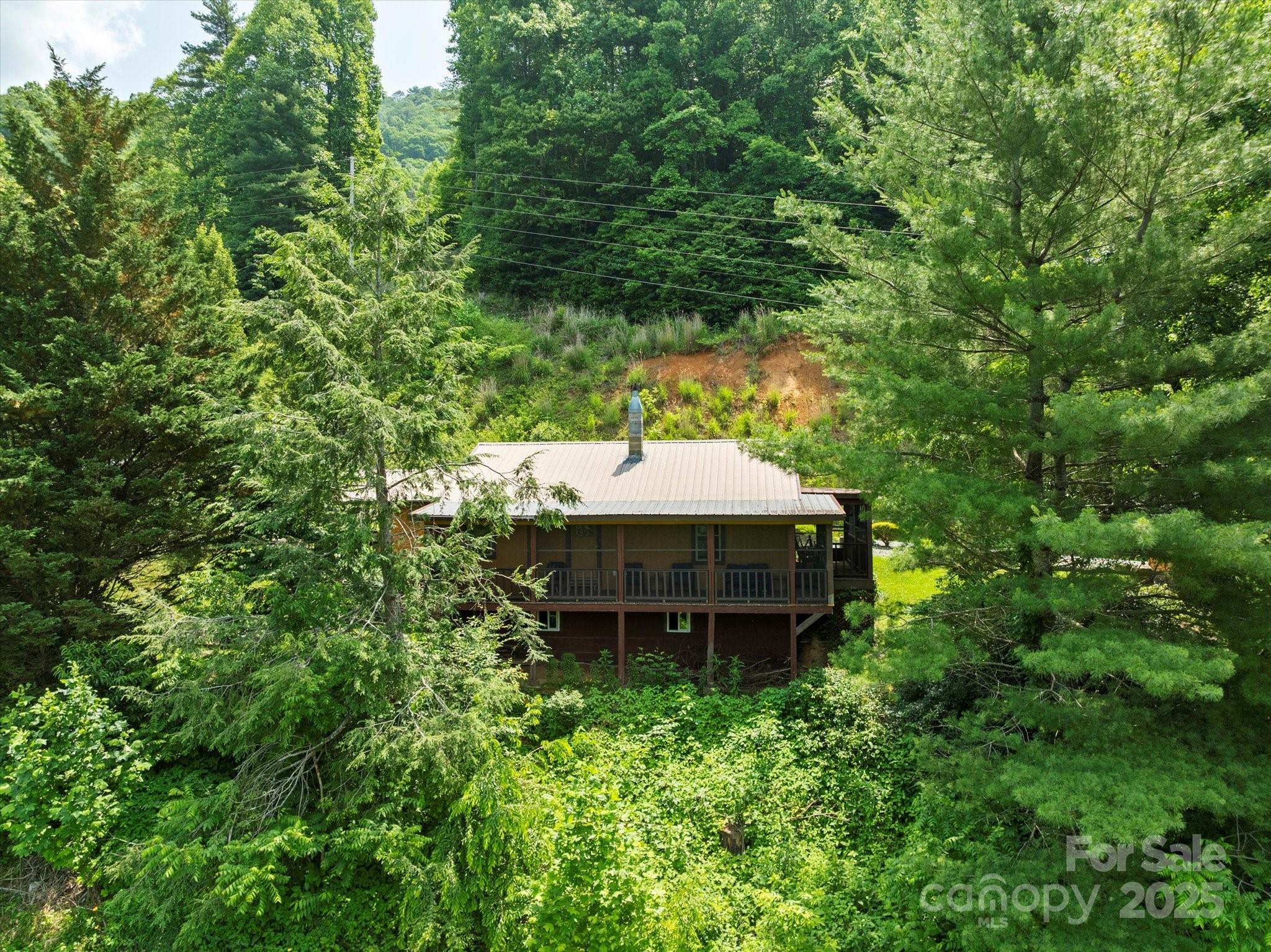 139 Ivy Ridge Church Road Mars Hill, NC 28754 - Photo 29 of 37 a backyard of a house with table and chairs under an umbrella