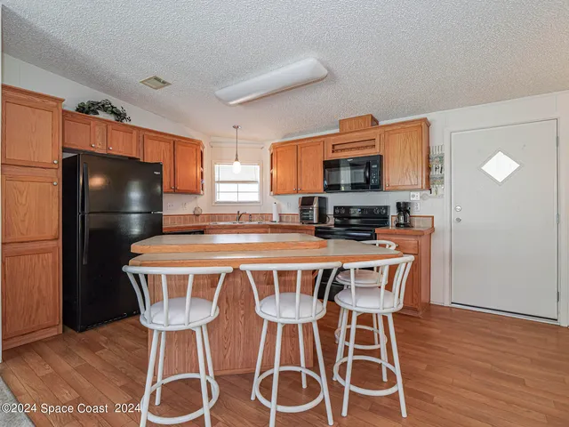 a kitchen with stainless steel appliances a dining table chairs and granite counter tops