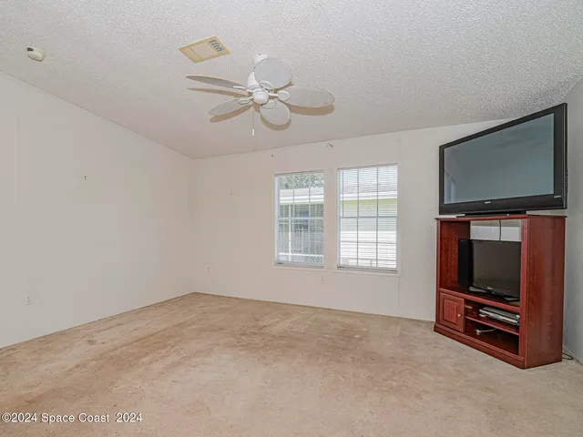a view of livingroom with furniture flat screen tv and windows